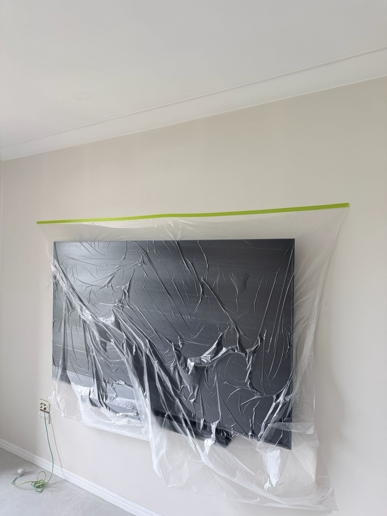 Professional interior painting preparation — furniture and fittings protected with plastic sheeting